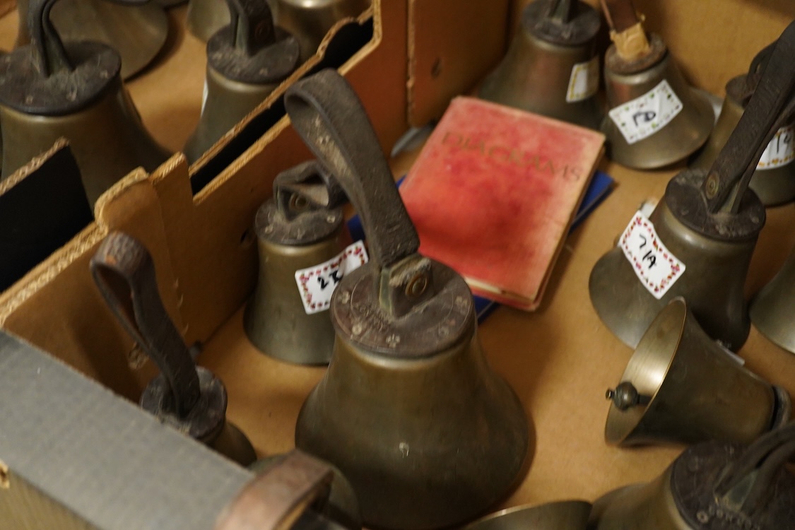 A set of twenty-two bronze handbells by Mears, London, with leather grips, together with two books from the Jasper Snowden Change Ringing Series, largest diameter 16cm